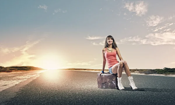 Girl traveler sitting on suitcase — Stock Photo, Image