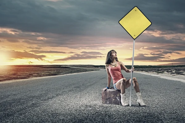 Girl traveler sitting on suitcase — Stock Photo, Image