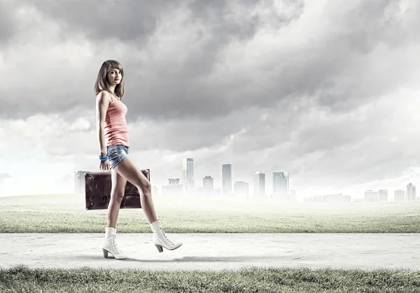 Turista con maleta caminando por carretera — Foto de Stock