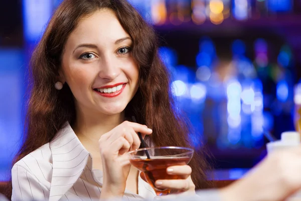 Дівчина в барі п'є коктейль — стокове фото