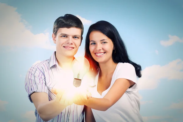 Casal segurando lâmpada elétrica — Fotografia de Stock