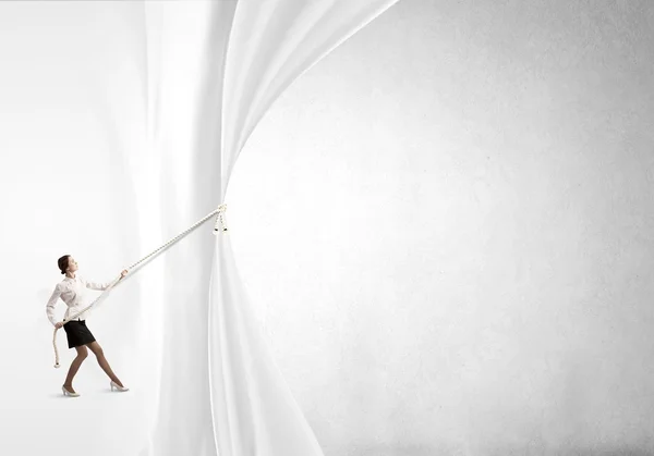 Businesswoman pulling curtain with rope — Stock Photo, Image