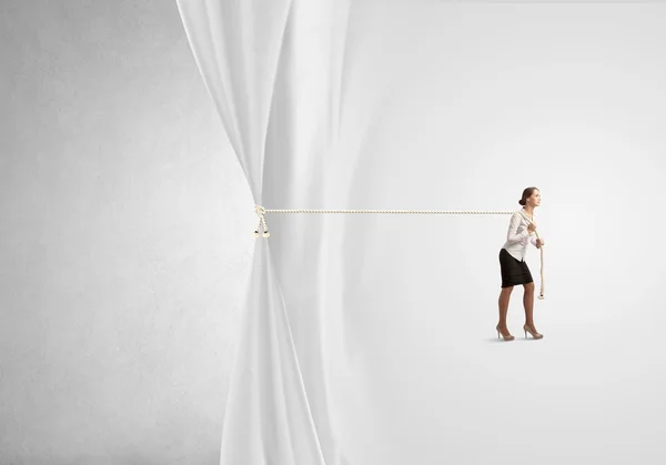 Businesswoman pulling curtain with rope — Stock Photo, Image