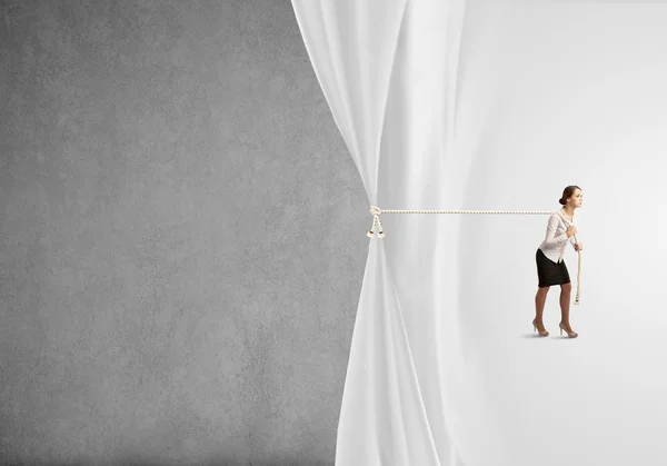 Businesswoman pulling curtain with rope — Stock Photo, Image