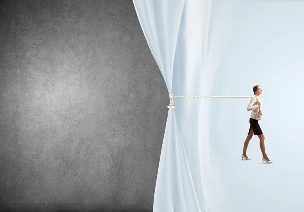 Businesswoman pulling curtain with rope — Stock Photo, Image