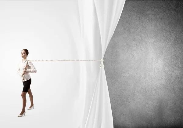 Businesswoman pulling curtain with rope — Stock Photo, Image