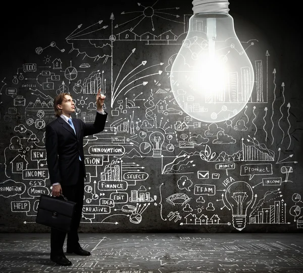 Businessman pointing at light bulb — Stock Photo, Image