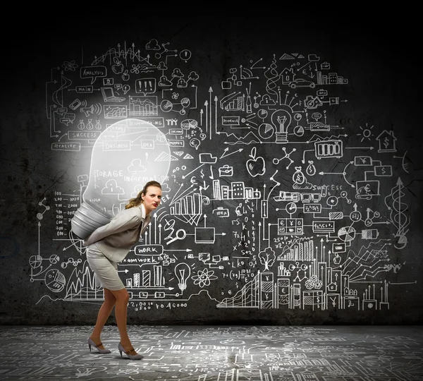 Businesswoman carrying light bulb — Stock Photo, Image