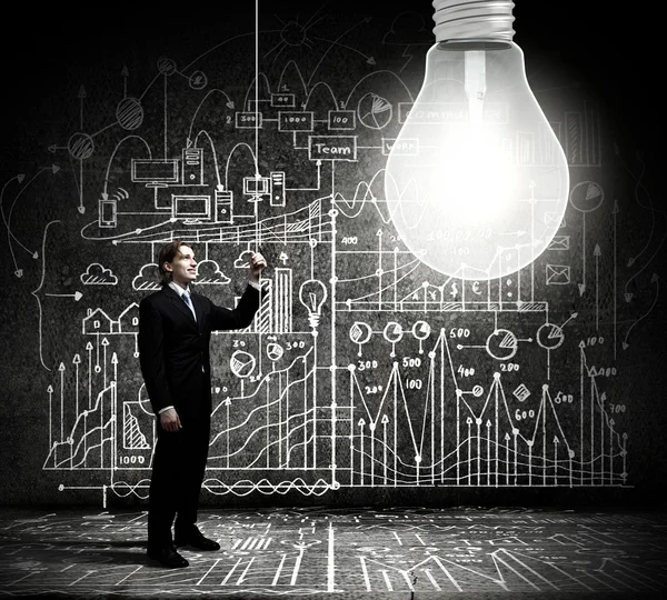 Empresário ligando a lâmpada — Fotografia de Stock