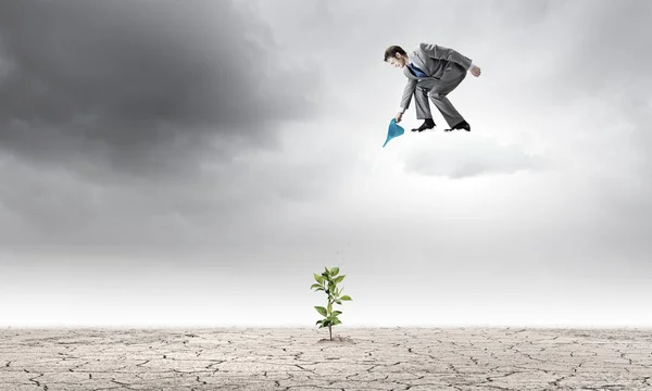 Geschäftsmann steht auf Wolke sieben und gießt Sprosse — Stockfoto