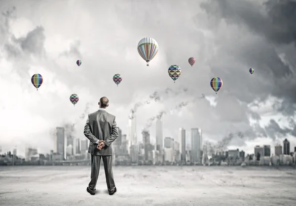 Empresario mirando globos — Foto de Stock