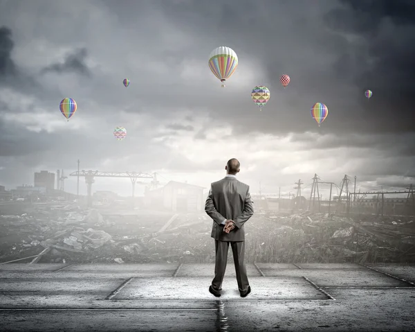 Бизнесмен смотрит на воздушные шары — стоковое фото