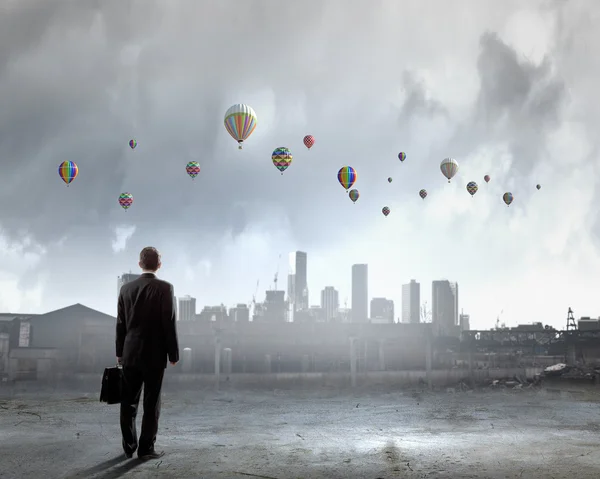 Geschäftsmann blickt auf Luftballons — Stockfoto