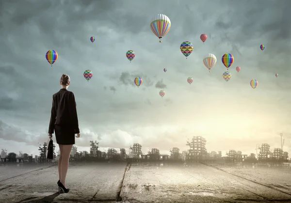 Бизнесмен смотрит на воздушные шары — стоковое фото