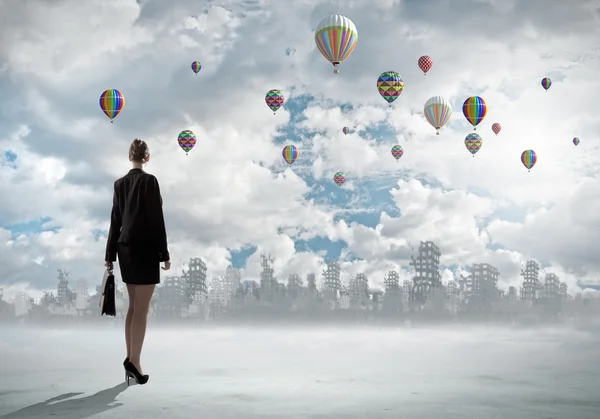 Businesswoman looking at balloons — Stock Photo, Image