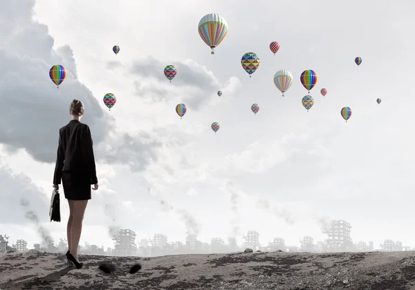 Businesswoman looking at balloons — Stock Photo, Image