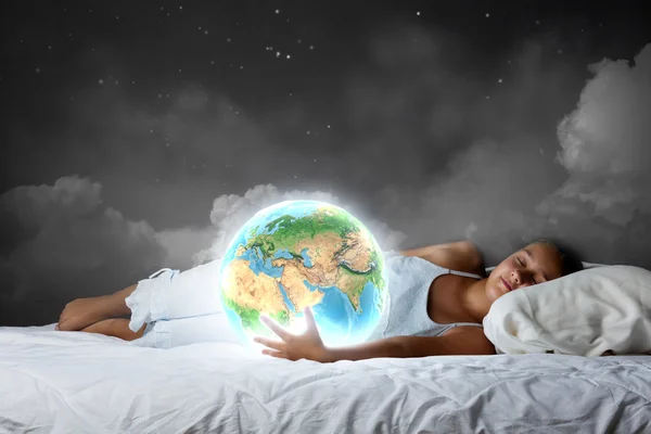 Girl sleeping in bed and holding Earth planet — Stock Photo, Image