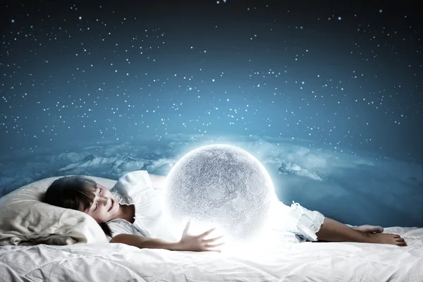 Girl lying in bed with moon — Stock Photo, Image