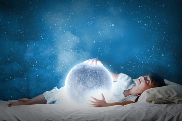 Girl lying in bed with moon — Stock Photo, Image