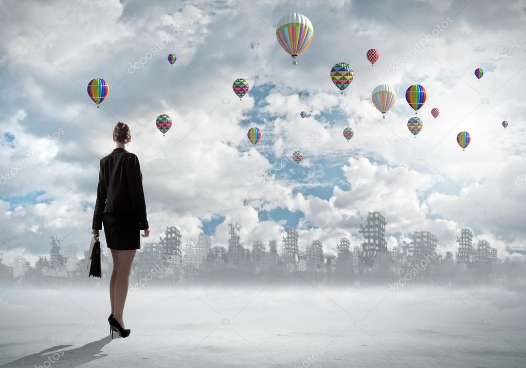 Businesswoman looking at balloons