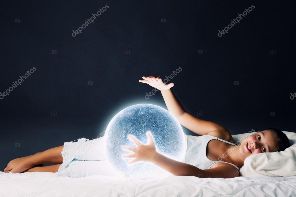 Girl lying in bed with moon