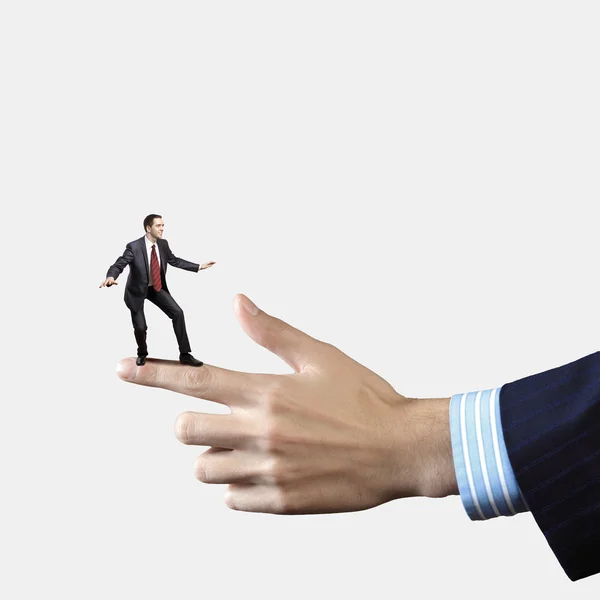 Businessman balancing on finger — Stock Photo, Image