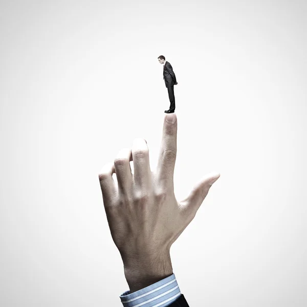 Businessman pointing at miniature of man — Stock Photo, Image