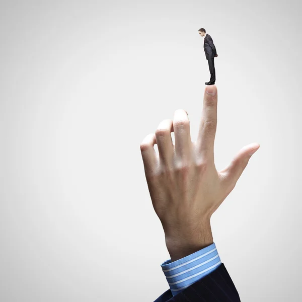 Businessman pointing at miniature of man — Stock Photo, Image