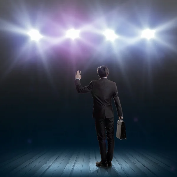 Geschäftsmann steht im Licht der Bühne — Stockfoto