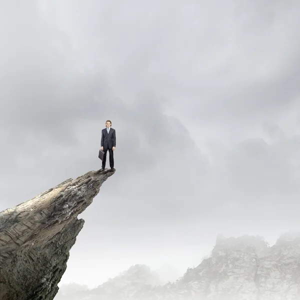 Empresário em pé na borda da rocha — Fotografia de Stock