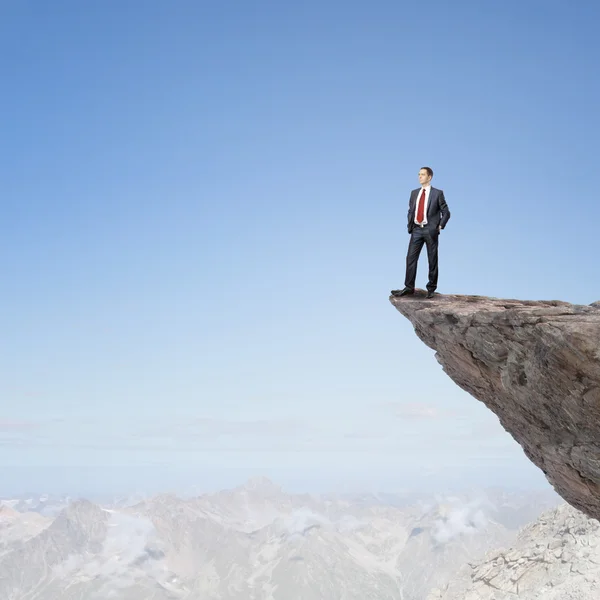Businessman on edge of rock mountain — Stock Photo, Image