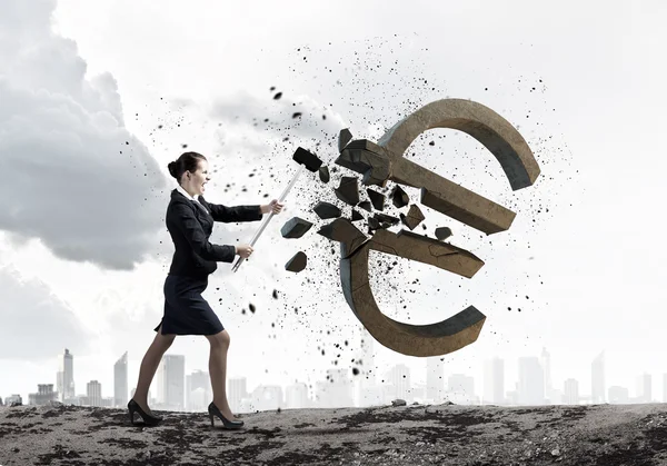 Businesswoman crashing stone euro symbol — Stock Photo, Image