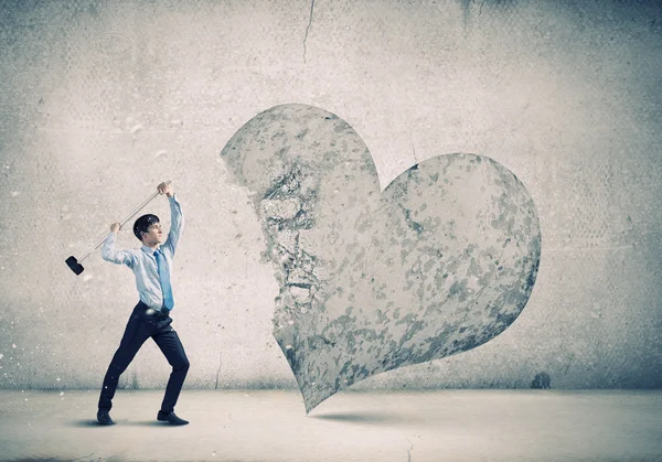 Hombre de negocios rompiendo el corazón de piedra —  Fotos de Stock