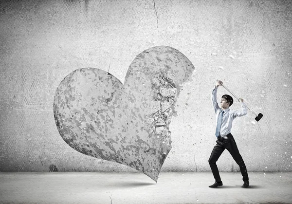 Hombre de negocios rompiendo el corazón de piedra — Foto de Stock