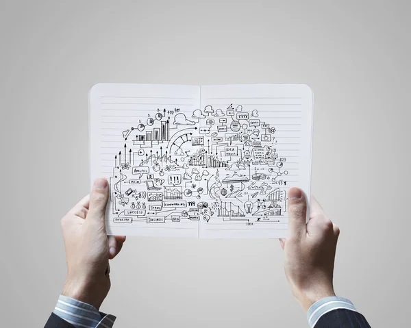 Hands holding notepad with sketches — Stock Photo, Image