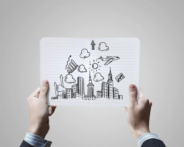 Hands holding notepad with sketches — Stock Photo, Image