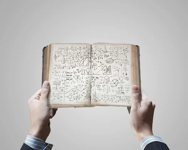 Manos sosteniendo libro abierto con bocetos — Foto de Stock
