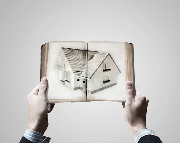 Hände halten Buch mit Hausbild — Stockfoto
