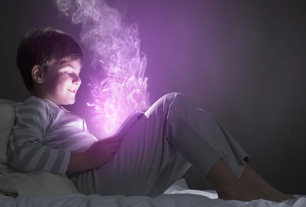 Boy using tablet pc in bed — Stock Photo, Image