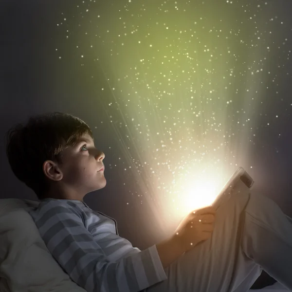Хлопчик використовує планшетний ПК у ліжку — стокове фото