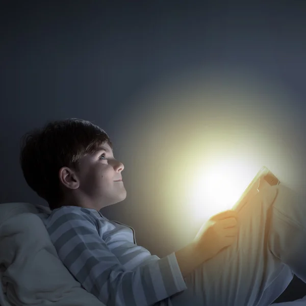 Boy using tablet pc in bed — Stock Photo, Image