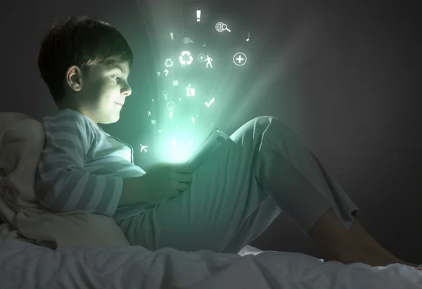 Chłopiec przy użyciu komputera typu tablet w łóżku — Zdjęcie stockowe