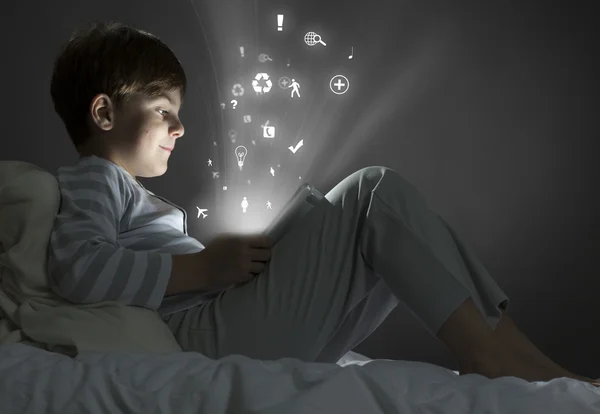 Boy using tablet pc in bed — Stock Photo, Image