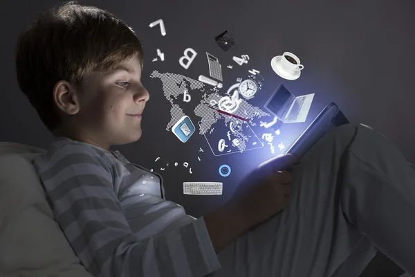Chłopiec przy użyciu komputera typu tablet w łóżku — Zdjęcie stockowe