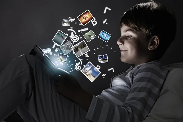 Αγόρι που χρησιμοποιούν tablet pc στο κρεβάτι — Φωτογραφία Αρχείου