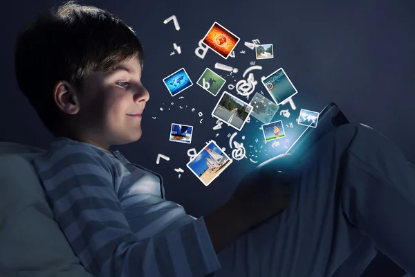 Niño usando tableta pc en la cama — Foto de Stock