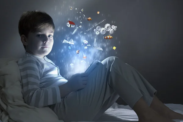 Boy using tablet pc in bed — Stock Photo, Image