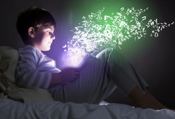 Boy using tablet pc in bed — Stock Photo, Image