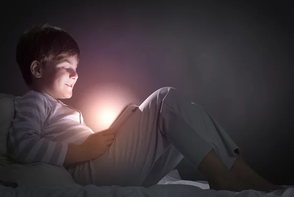 Ragazzo utilizzando tablet pc a letto — Foto Stock