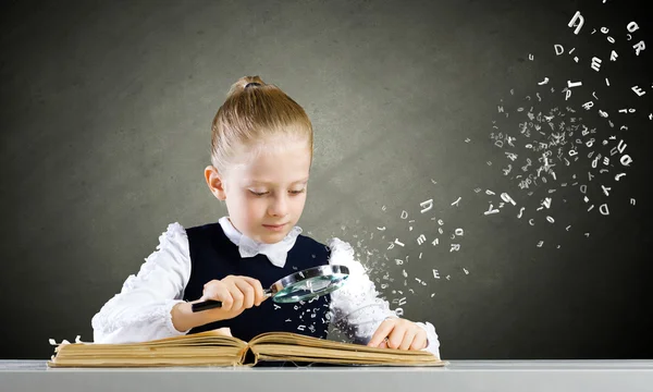 Schoolgirl examining book — Stock Photo, Image